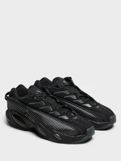 Nocta Glide Sneakers i Black, Black, Iron Grey og University Gold